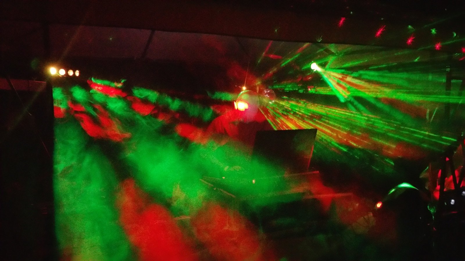 Grün-rote Laser-Lichtshow im Nebel auf der Tanzfläche