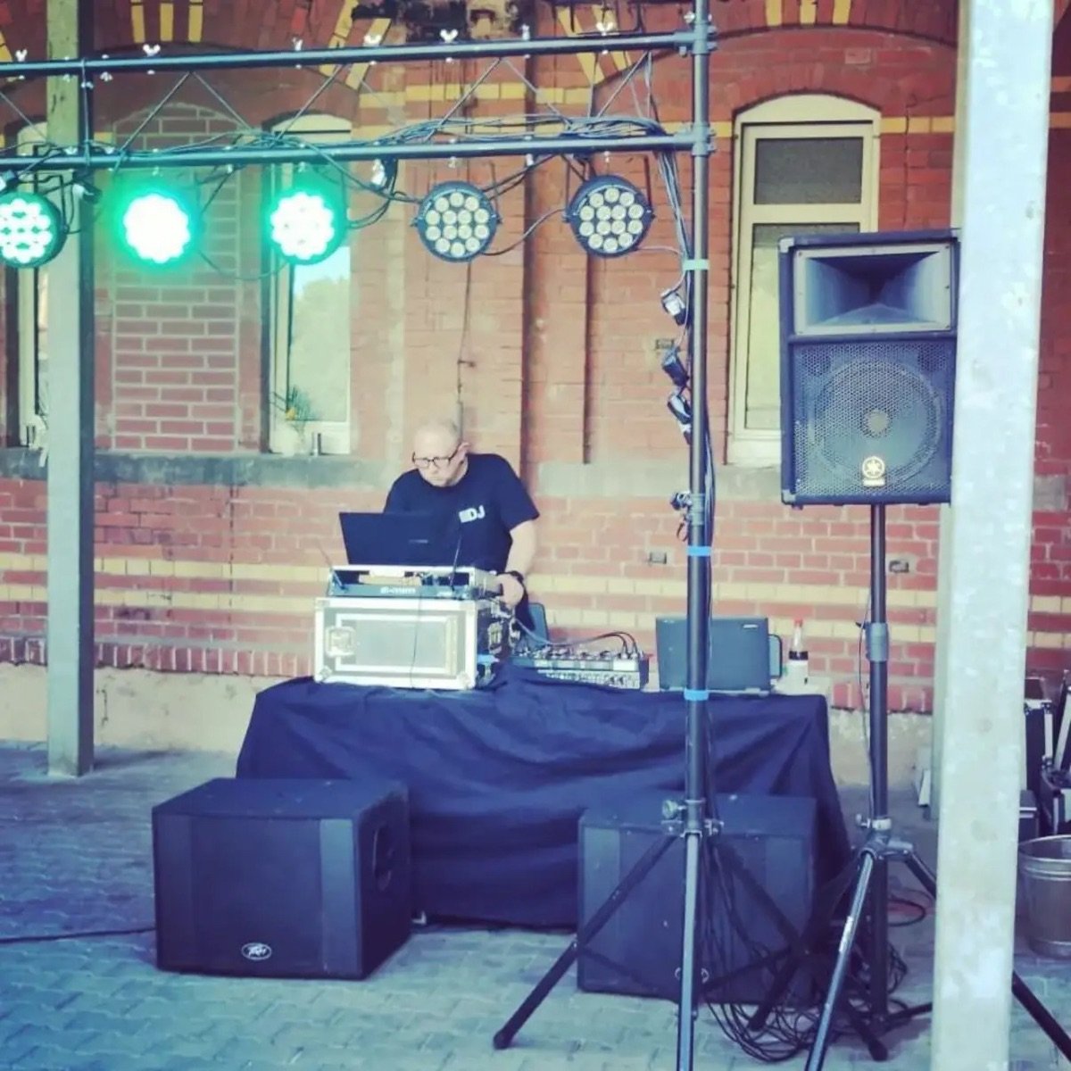 DJ Marko Glöckner an den Decks bei einem Open-Air-Auftritt mit Lichttraverse und PA